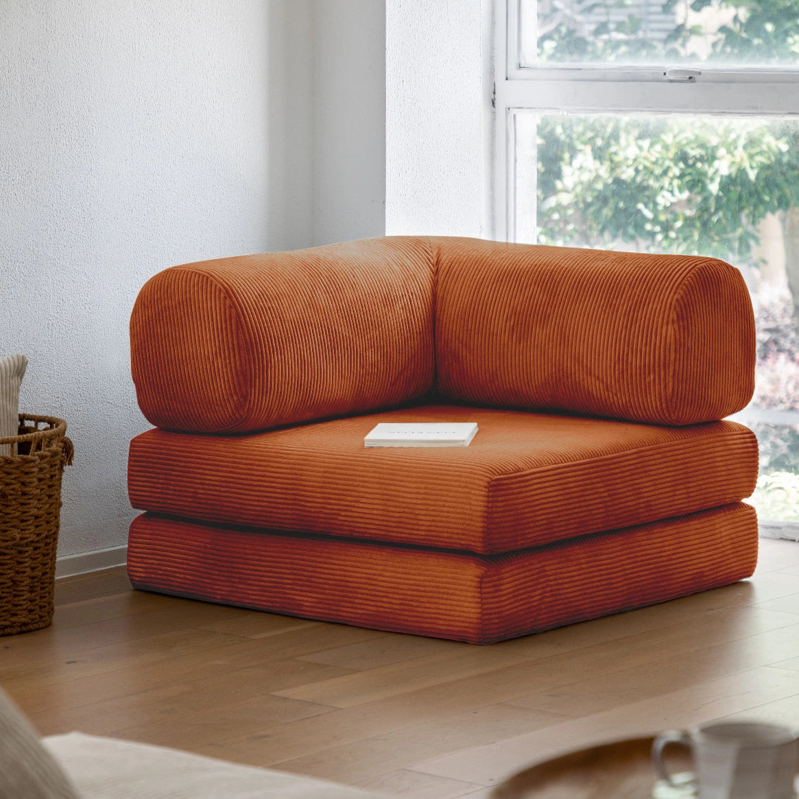 Orange corner sofa in a living room with a window in the background