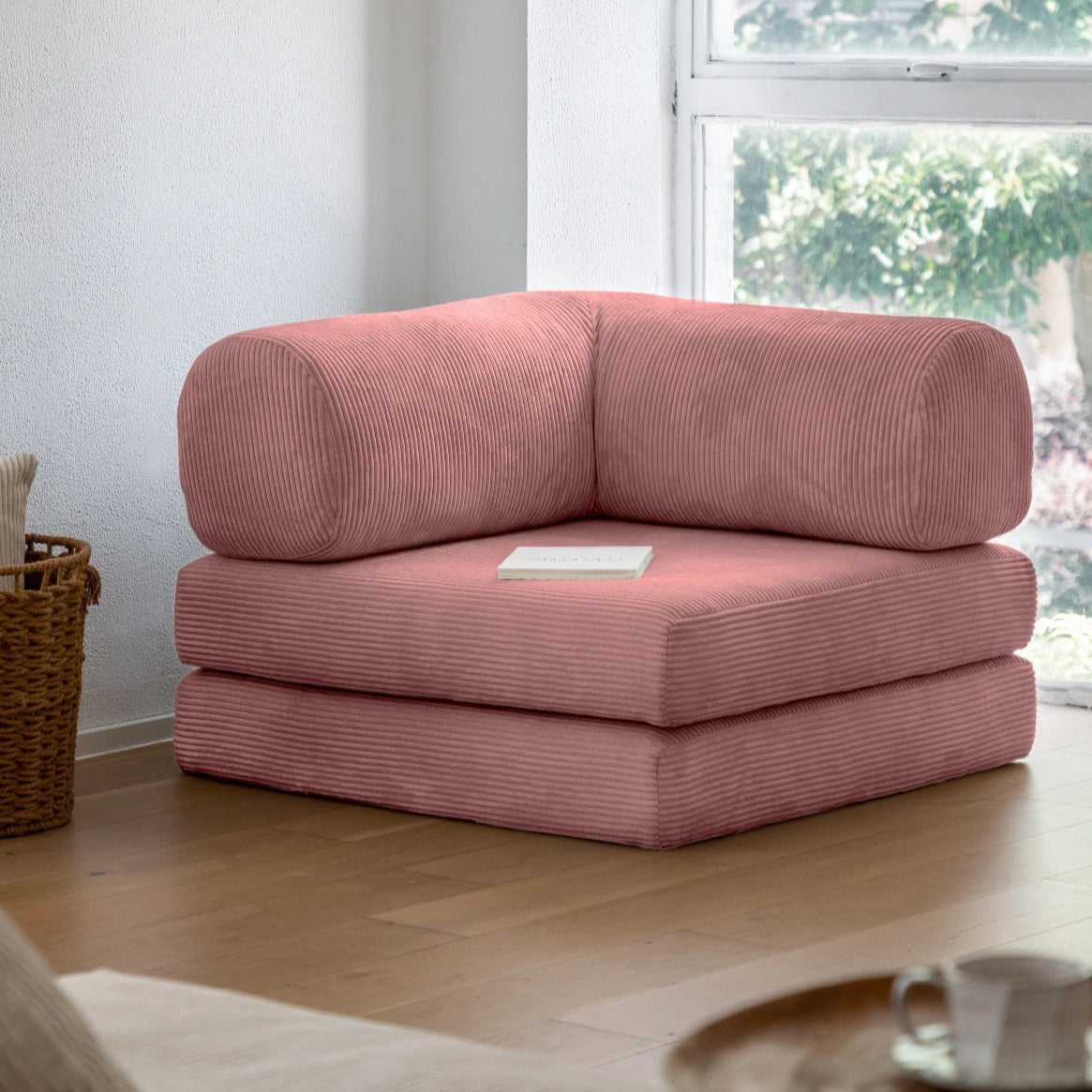 Pink corner sofa in a living room with a window in the background