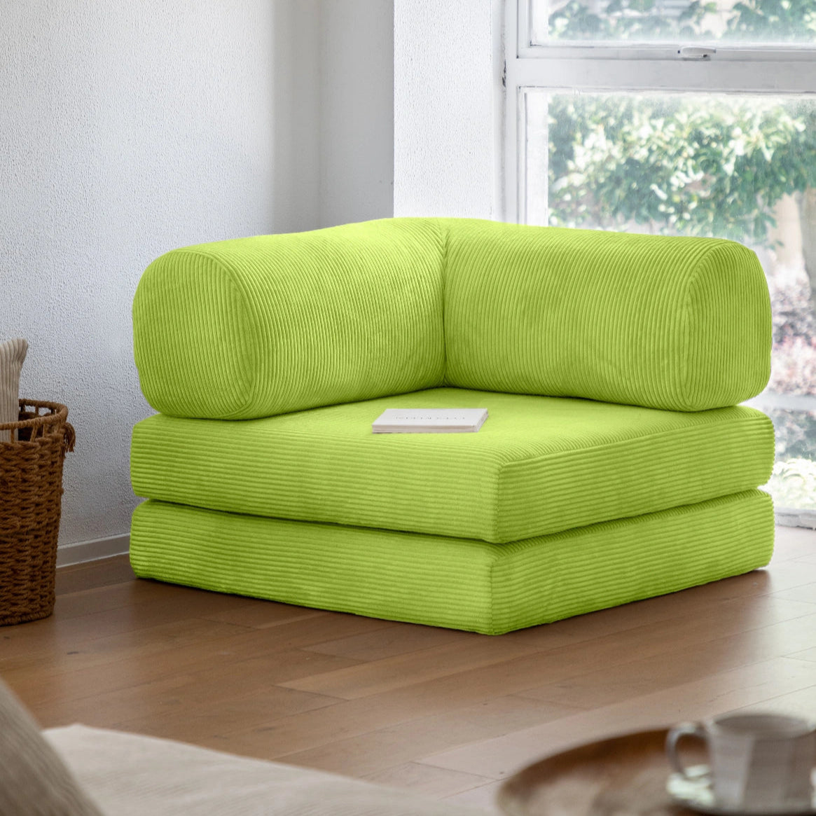 Green modular sofa in a living room with a window in the background