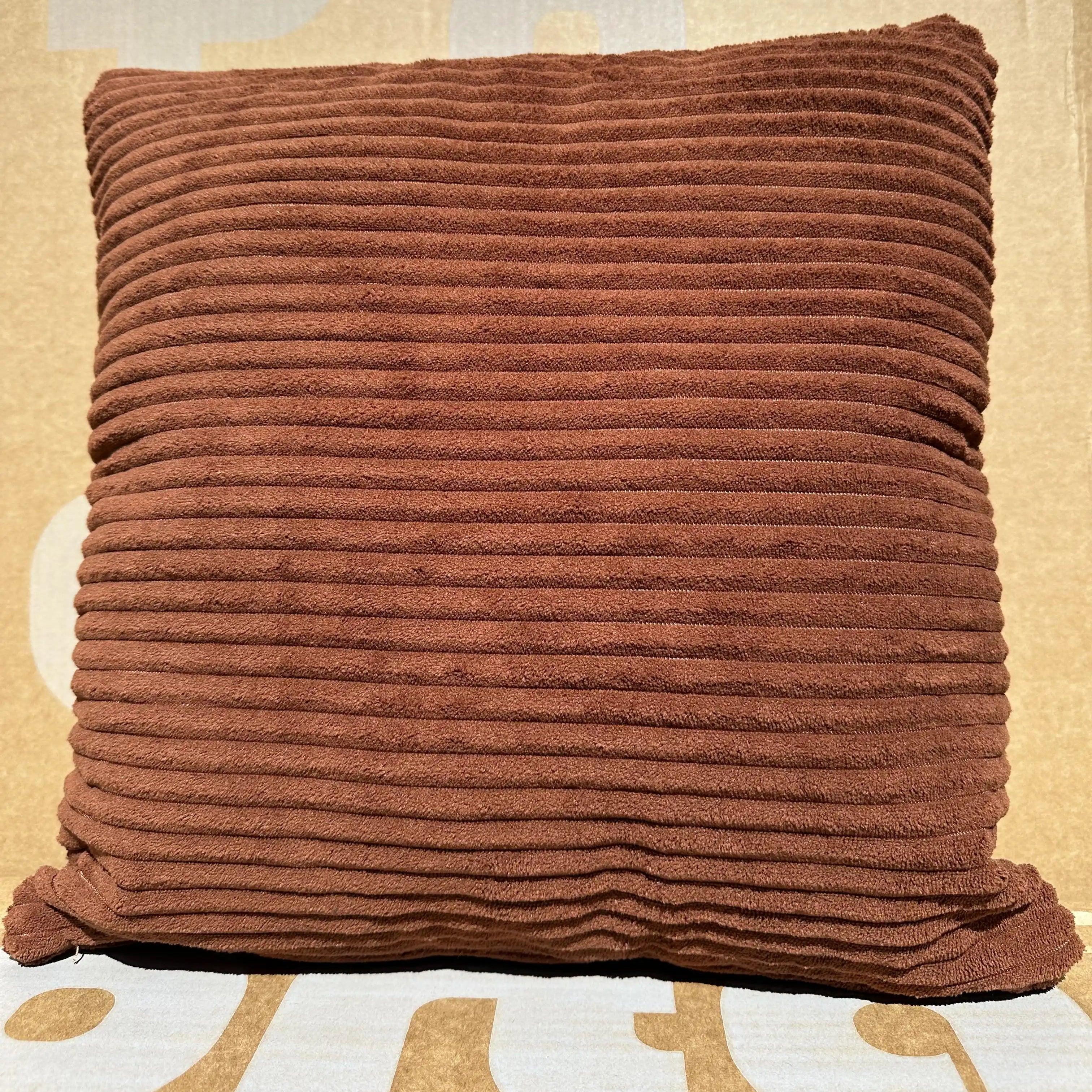 Brown textured pillow on a patterned surface