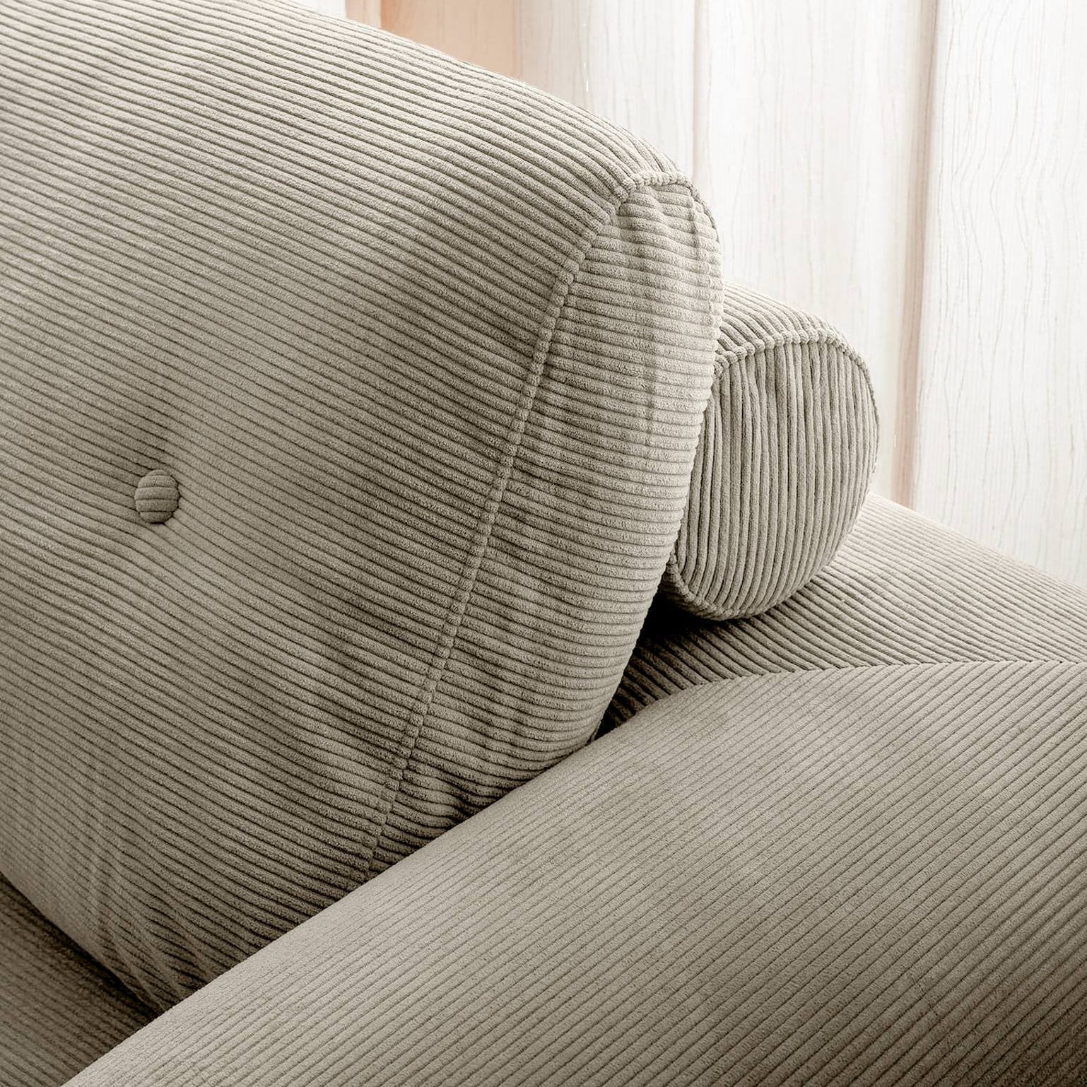 Gray striped sofa with a cushion in a softly lit room.