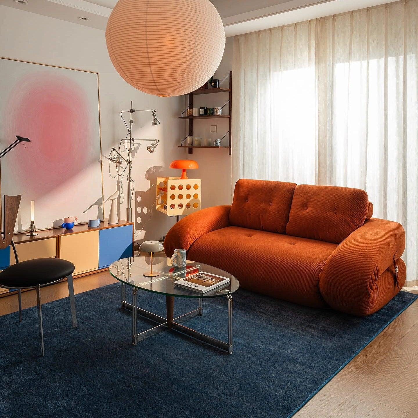 Flippo Sofa Bed in Orange color – sculptural design with plush corduroy, convertible to bed, modern furniture style
