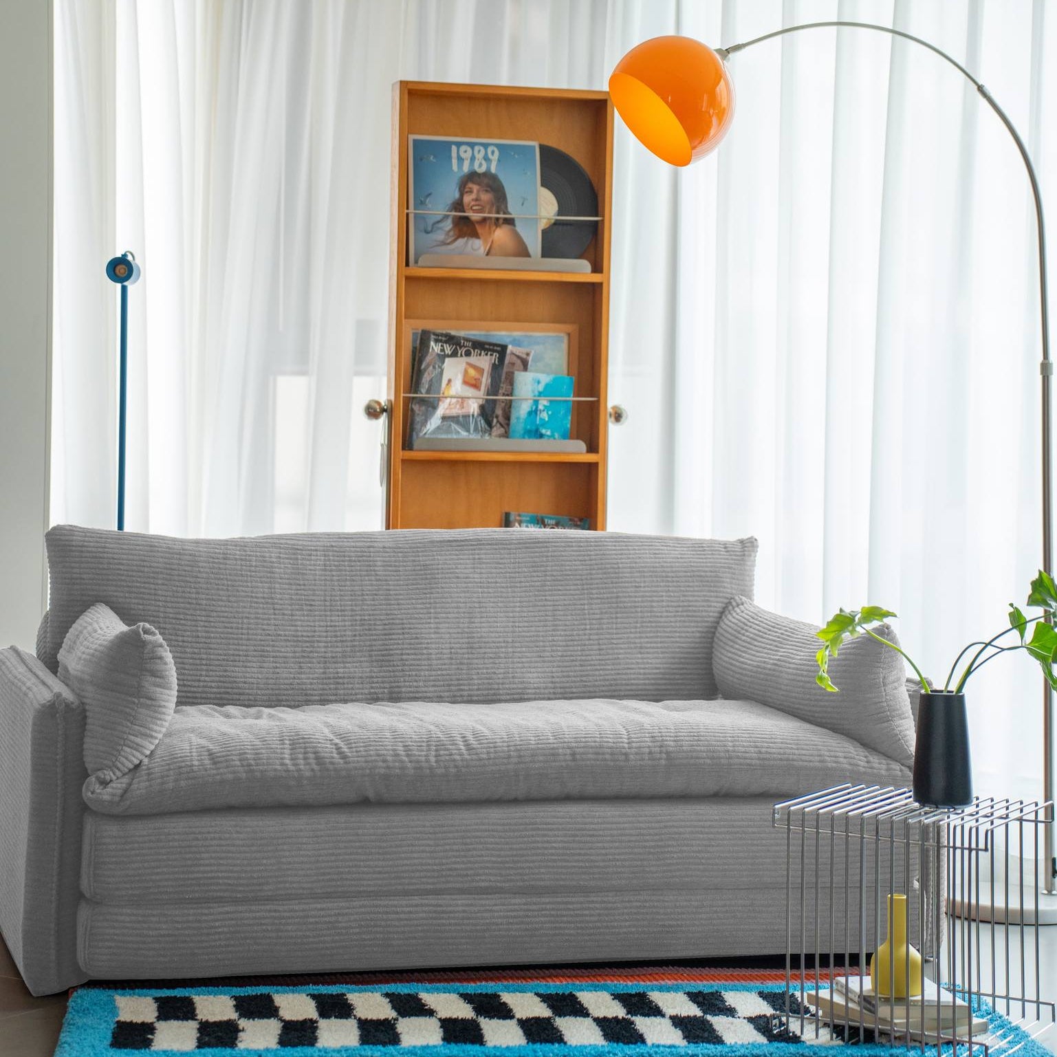 Living room with gray sofa, bookshelf, and decorative elements.
