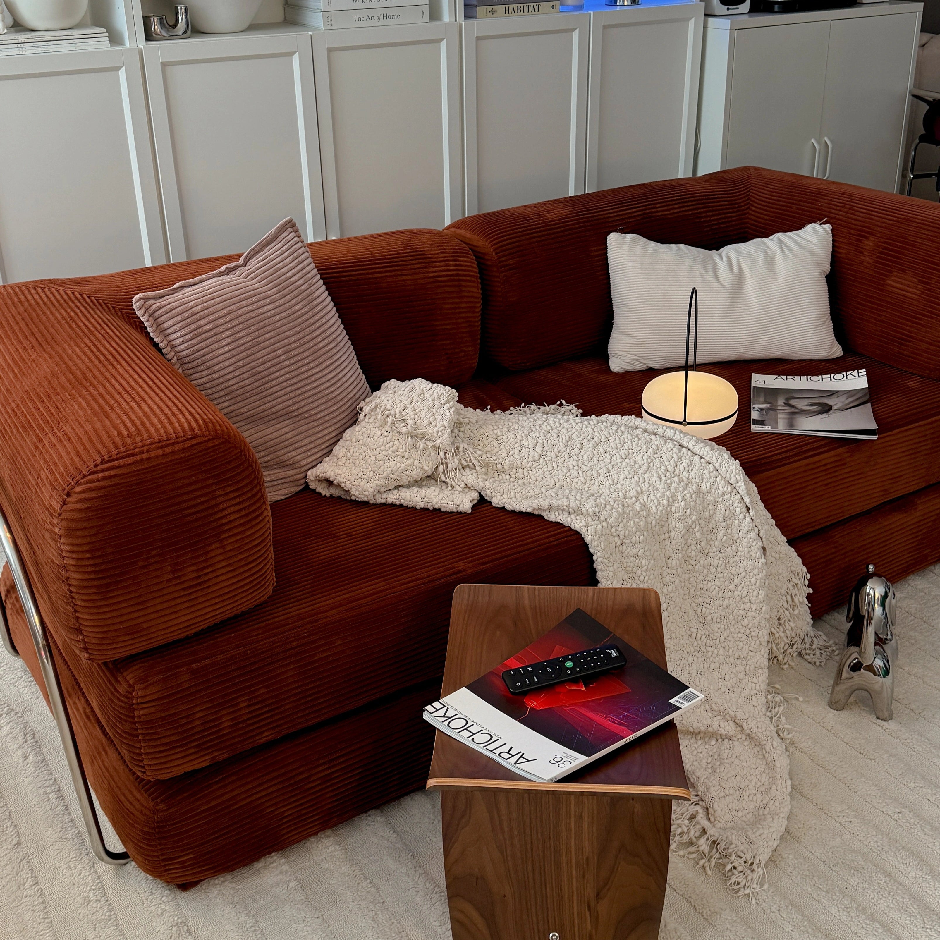 Living room with brown sofa, wooden coffee table, and decorative items.