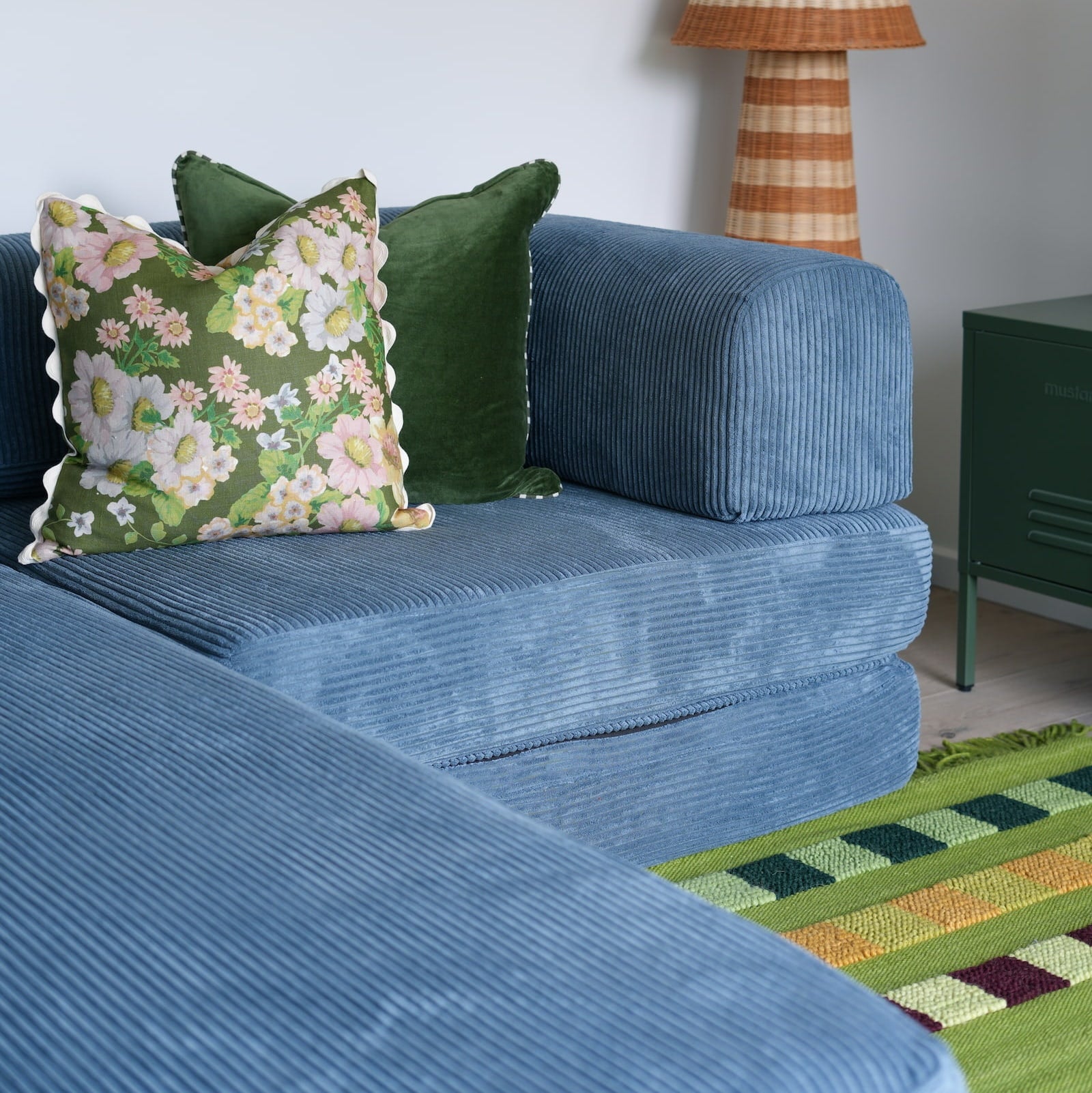 Blue sofa with decorative pillows and a lamp in a living room settingnn