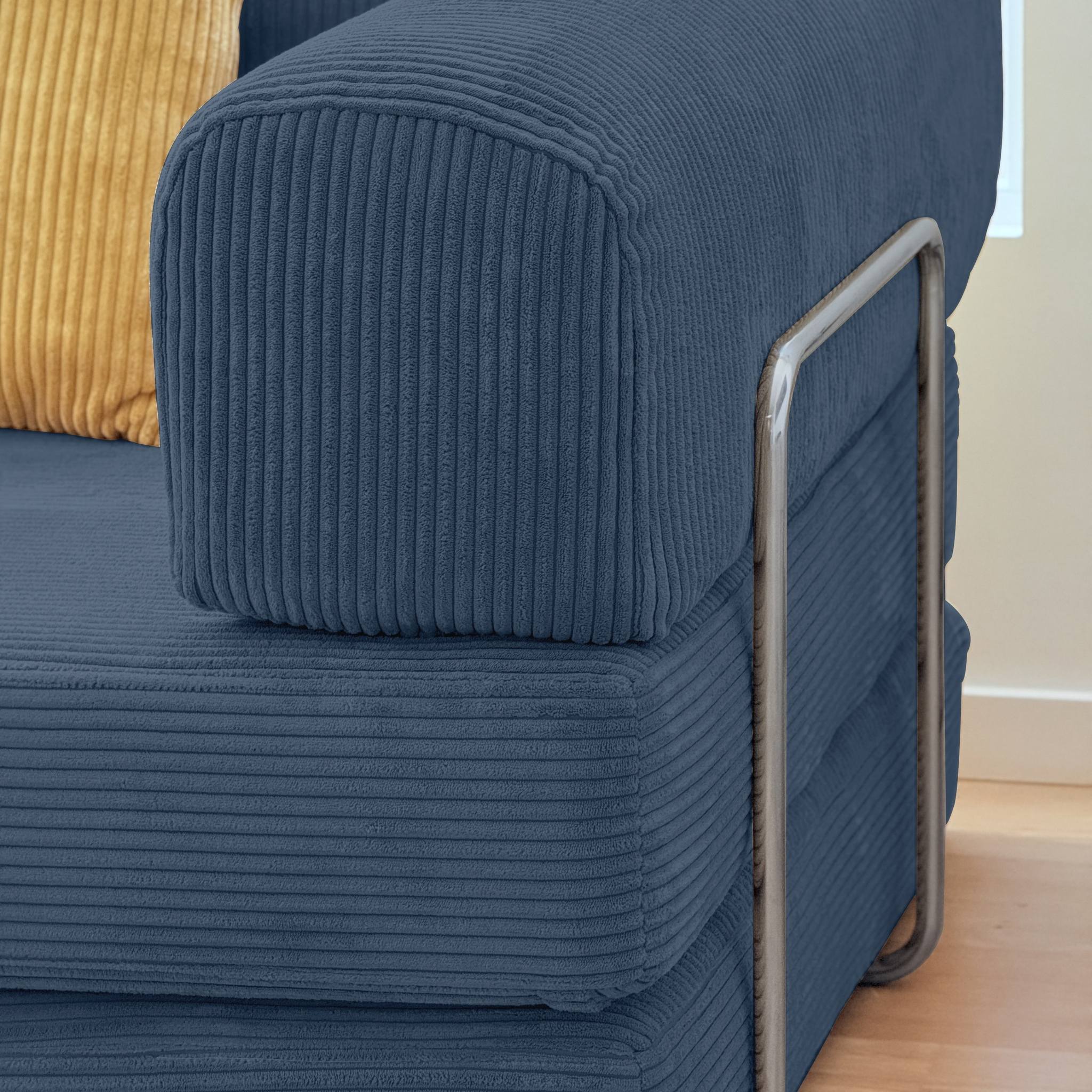 Blue textured sofa with a metal armrest on a wooden floor.