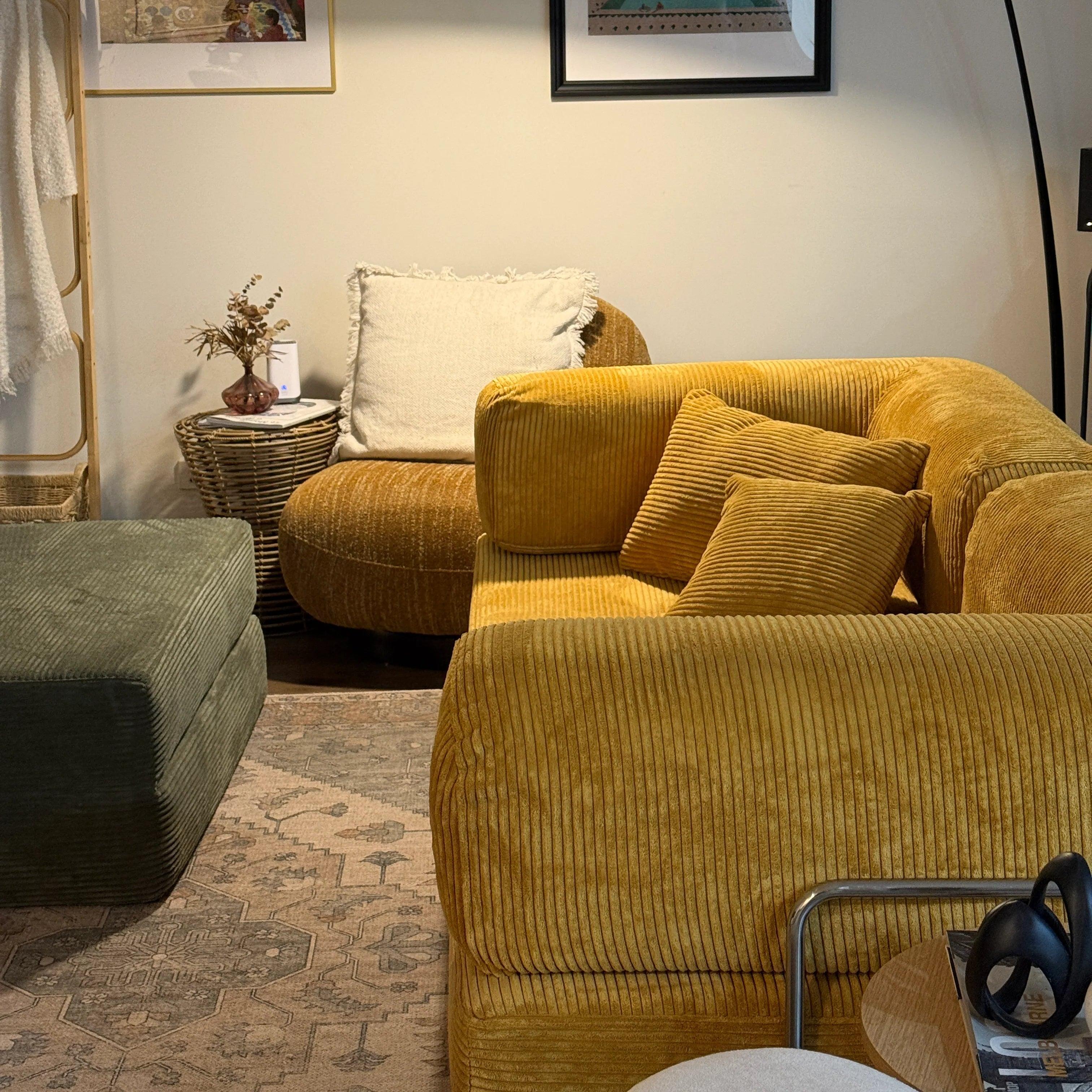 Yellow corduroy sofa in a living room setting with a neutral color palette.