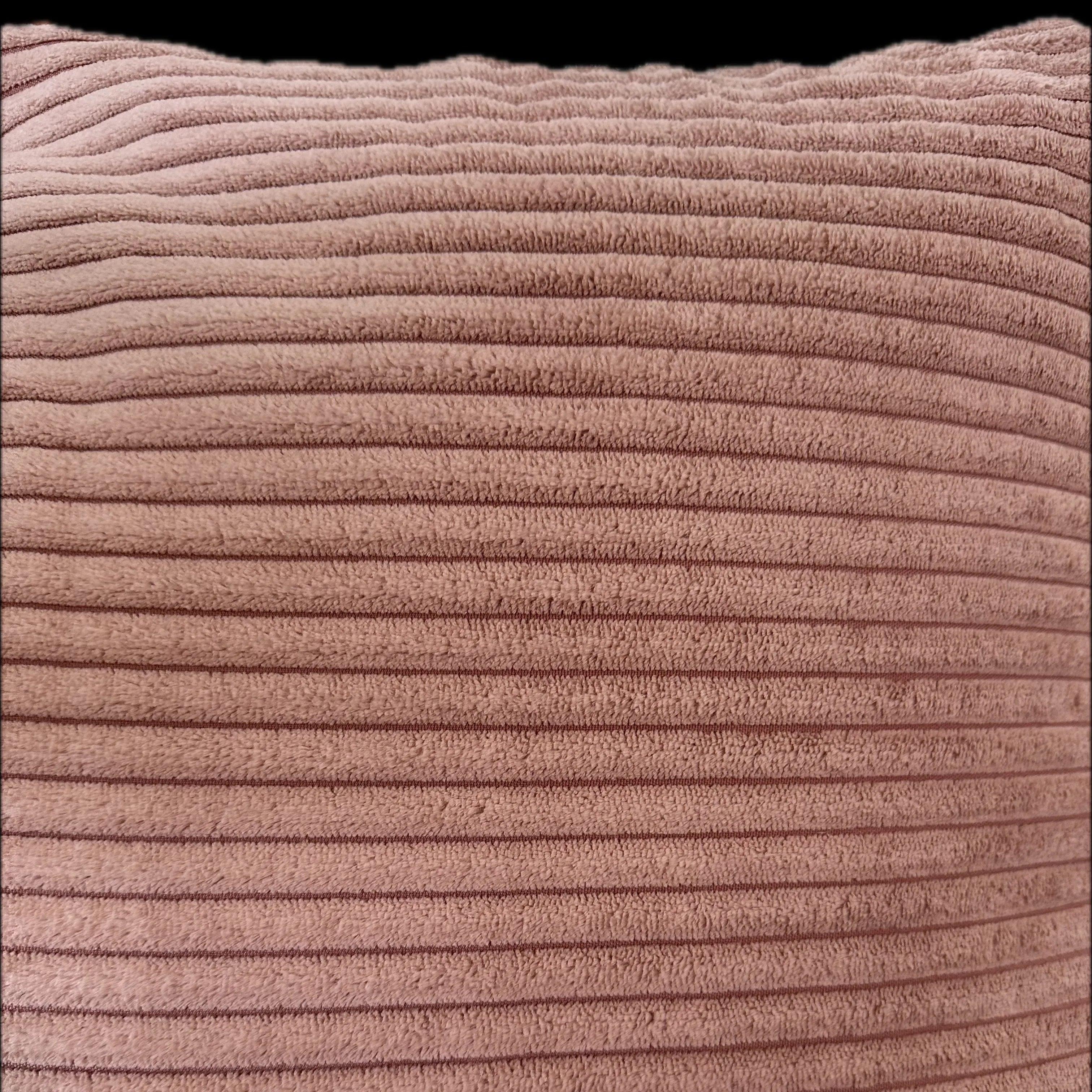 Close-up of a textured pink cushion with wavy pattern