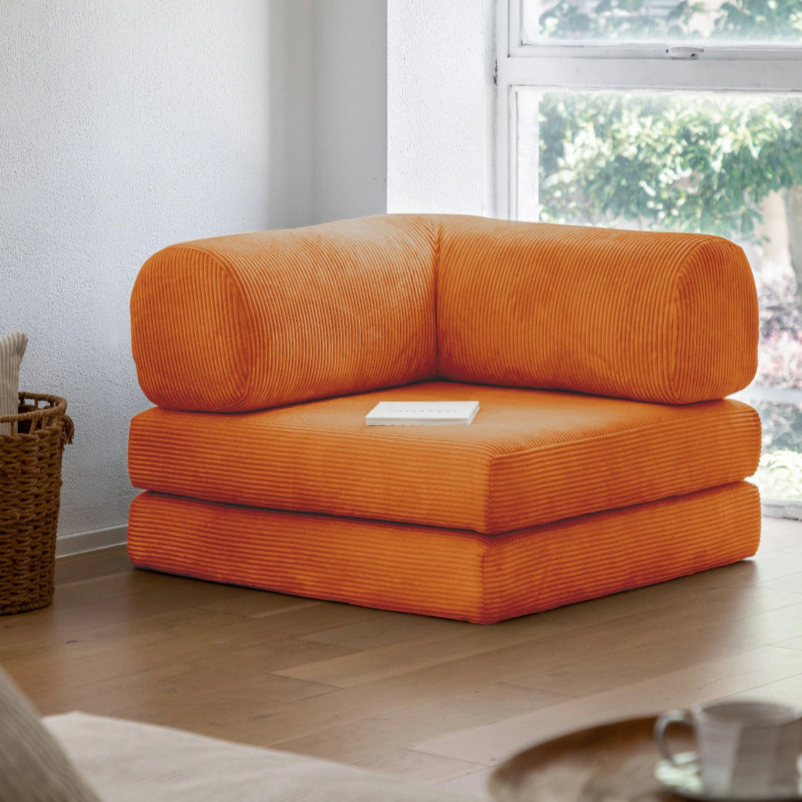 Orange corner sofa in a living room with a window in the background