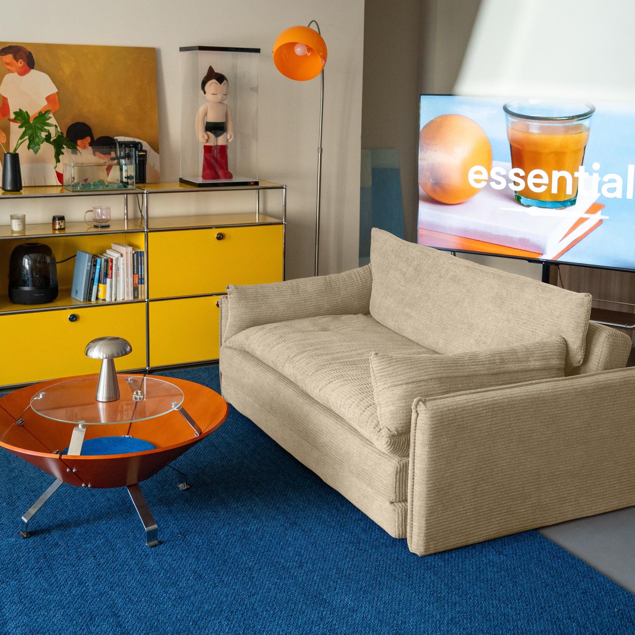 Beige sofa with a textured fabric in a room with a yellow cabinet and blue carpet.