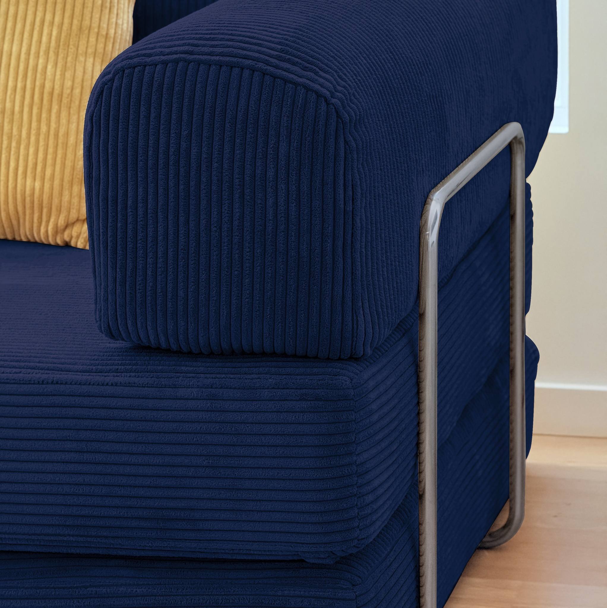 Blue ribbed sofa bed with a metal handle on a wooden floor.